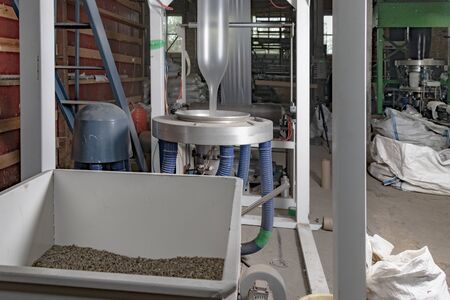 Production of plastic bags from recycled waste granules. Loading of polyethylene granules. Extruder blows polyethylene sleeve. Folding plastic bags into a roll.の写真素材
