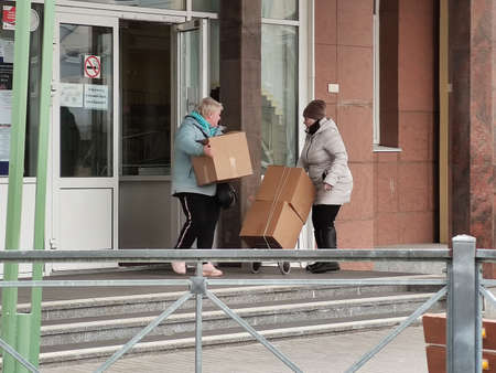 April 6, 2019, St. Petersburg, Russia: Women carry humanitarian aid from school. Helping parents in difficult situations during the coronavirus pandemic COVID-19. Food boxesのeditorial素材