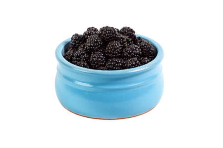 Ripe garden blackberry in a ceramic bowl on a white isolated backgroundの写真素材