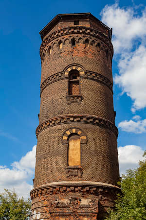 Ancient water tower on a background of cloudy sky (vertical image)