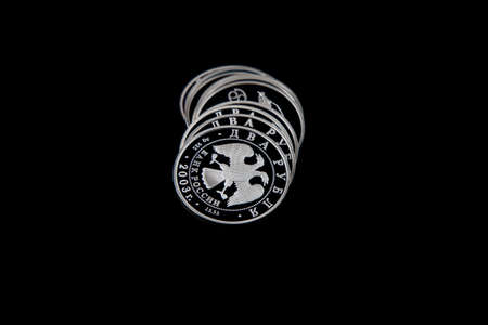 Fallen pyramid of silver coins of the Bank of Russia on a black isolated background. The upper coin...