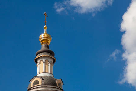 Gilded cross on the bell tower of the Orthodox Church.