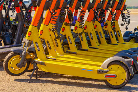 Electric scooters stand in a row at the rental point.の写真素材