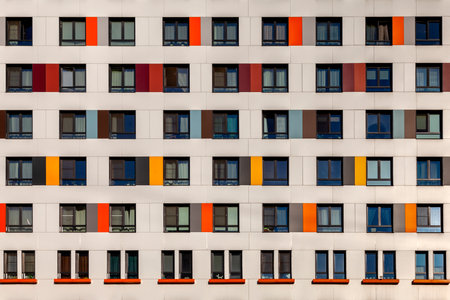 Background image wall of a modern high-rise building with windows and colorful decorative panels.のeditorial素材