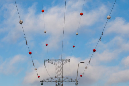 High-voltage power line with wires on which multi-colored balls are attached.の写真素材
