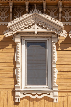 Picturesque window of an old wooden house with a carved frame.の写真素材