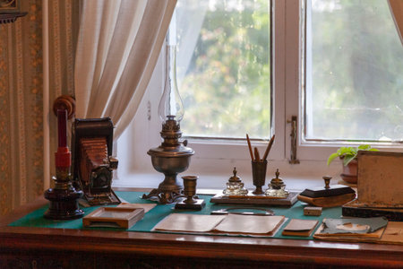 A writing desk with antique household items arranged on it.
