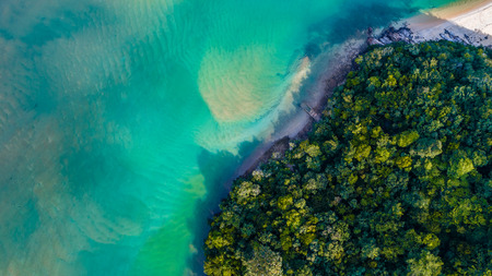 Aerial view of a beautiful ocean and white sandy beach at Bukit Keluang, Terengganu, Malaysia from a drone