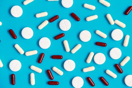 Close up flat lay of pills and tablets laying on the blue background.の写真素材