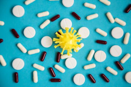 Coronavirus symbol laying on the pills and tablets on the blue background. Stop covid-19 pandemic.の写真素材
