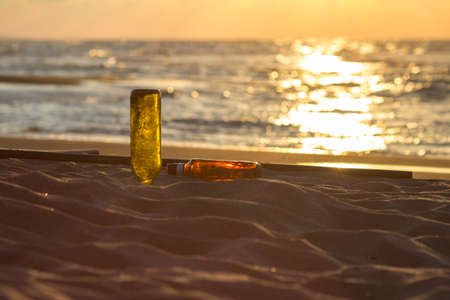 Bottle on the beach at sunset.の写真素材