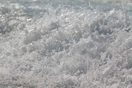 Sea waves with foam on the surface of the water, close-up