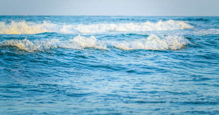 Beautiful sea waves with splashes of water on a sunny day