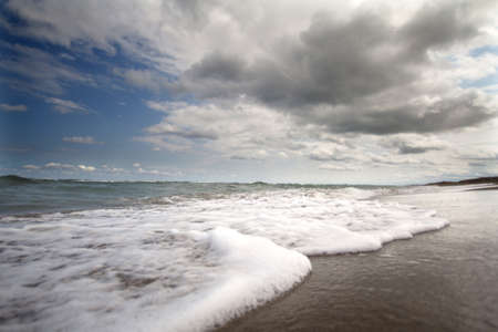 beautiful seascape with storm clouds and waves on the beachの写真素材