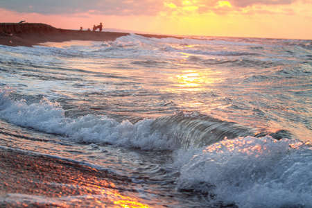 Beautiful sunset over the sea. Sea waves on the shore.の写真素材