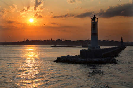Sunset over the sea and the lighthouse in the city of Istanbulの写真素材