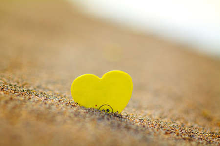 Yellow heart on the sand. Valentines day concept. Selective focus.の写真素材