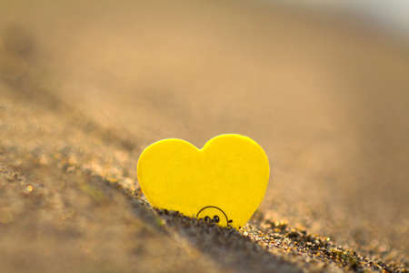 Yellow heart on the sand. The concept of love and romance.の写真素材