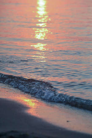 Sunset on the beach. The sun is reflected in the water.の写真素材