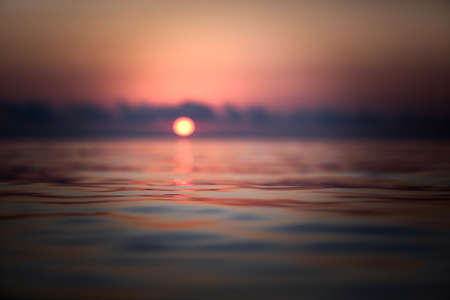 Beautiful sunset on the sea. The sun is reflected in the water.の写真素材