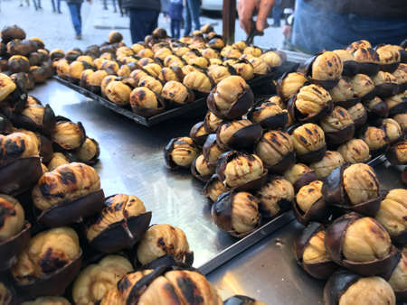 Baked chestnuts on display at a street food stall in Barcelonaの写真素材