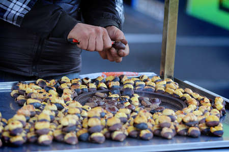 A street vendor is selling roasted chestnuts on a street stall.の写真素材