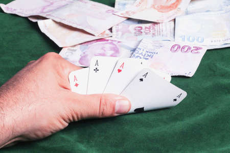 Playing cards and money in hand, close-up. Casino concept