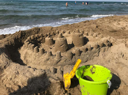 Sand castle and bucket on the beach. Sand castle on the beach.の写真素材