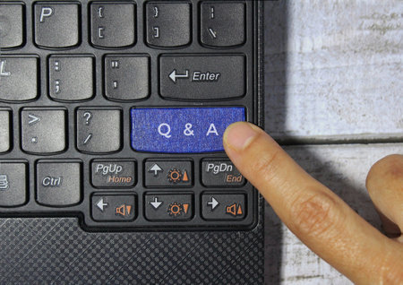 Top view of finger pressing blue key labeled with Q and A.の写真素材