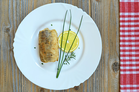 A plate with fried fish on wooden backgroundの写真素材