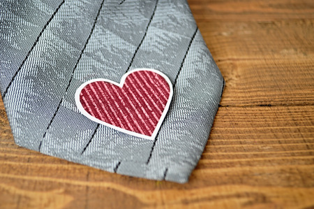 Father's Day gift: Grey tie and paper heart on wooden background
