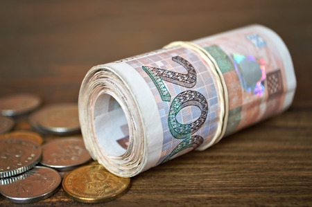 Coins and rolled banknotes tied with rubber band