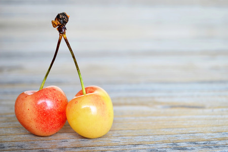Two sweet cherries on wooden backgroundの写真素材