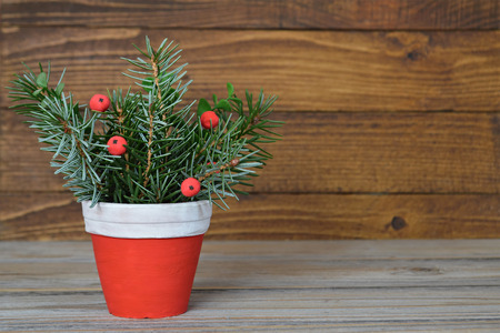 Christmas arrangement in clay pot on wooden backgroundの写真素材
