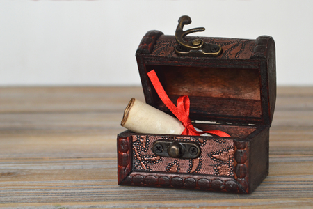 Old paper roll inside treasure chestの写真素材