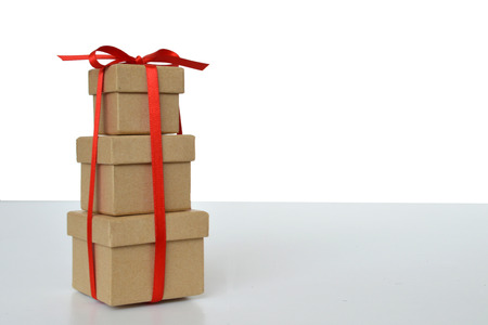 Three gift boxes tied together with red ribbon on light backgroundの写真素材