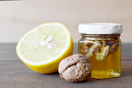 Jar of honey with walnuts and lemonの写真素材