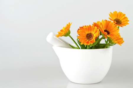 Marigold flowers in a mortar on light backgroundの写真素材