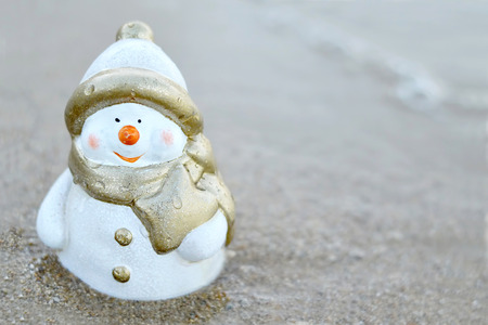 Christmas Snowman on the sandy beachの写真素材