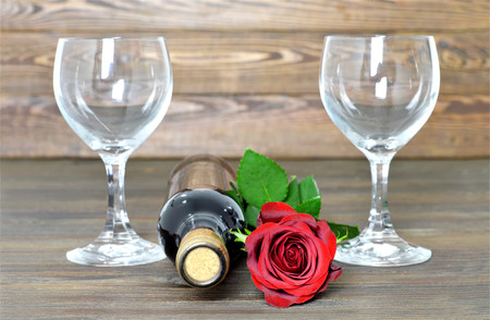 Red rose, bottle of red wine and two wine glassesの写真素材