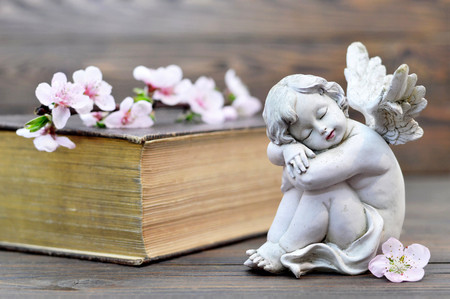 Angel guardian sleeping on wooden backgroundの写真素材