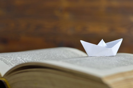 Paper boat on the old bookの写真素材