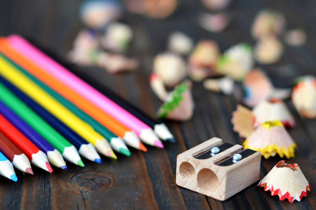 Back to school: Colored pencils and sharpener on wooden backgroundの写真素材