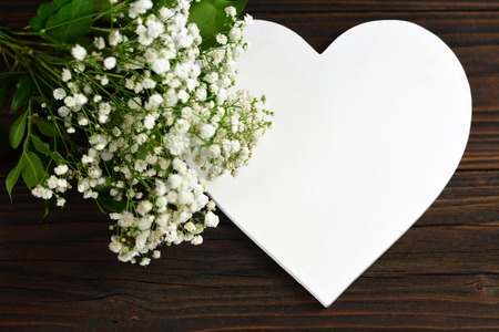 Wedding concept. White heart and white flowers on wooden backgroundの写真素材