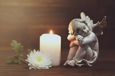 Angel, white flower and burning candleの写真素材