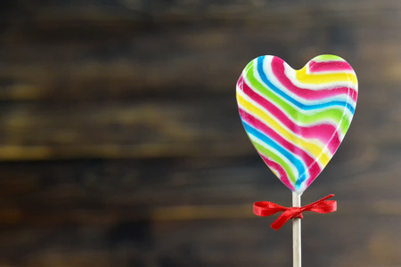 Valentines Day card. Heart shaped lollipop on wooden backgroundの写真素材