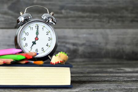 Back to school background. School supplies and alarm clock on wooden backgroundの写真素材