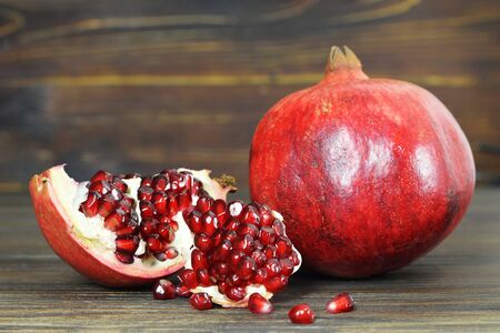 Ripe pomegranate on wooden backgroundの写真素材
