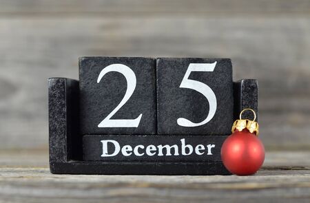 Wooden retro calendar with the date of Christmas and red Christmas ballの写真素材