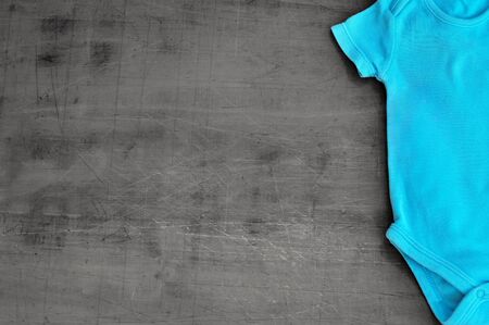 Baby bodysuit on wooden background with copy spaceの写真素材
